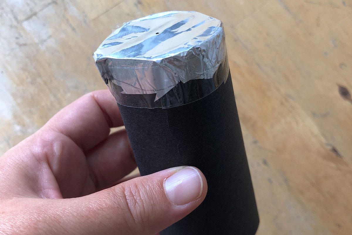 Eine Hand hält eine selbstgebastelte Lochkamera.